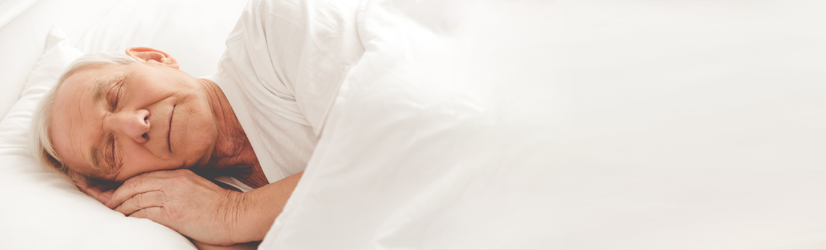 elderly man sleeping comfortably in a bed