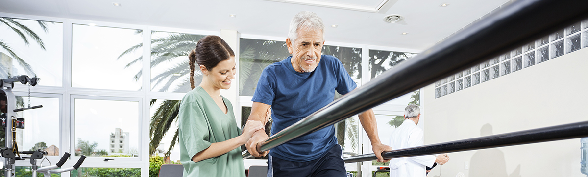 Therapist helping patient walk