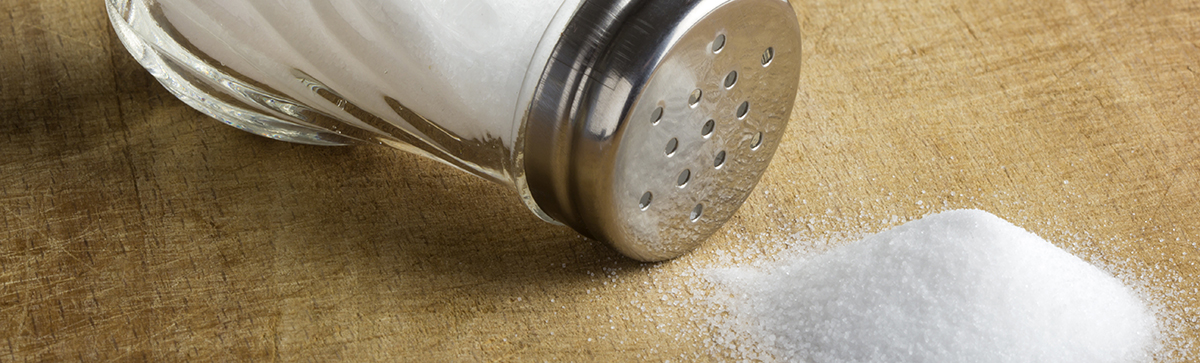 Spilled salt next to a salt shaker