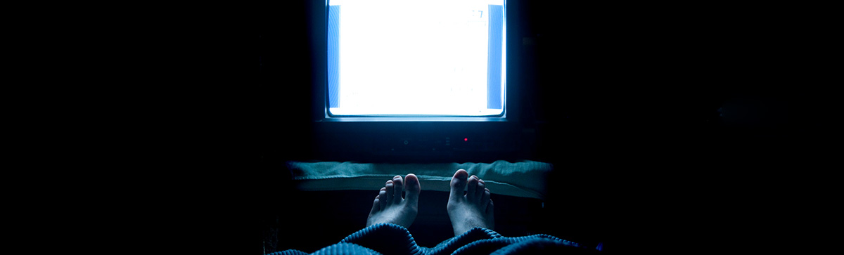 Television lighted in a dark bedroom