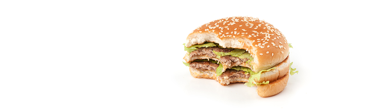 Tasty big hamburger with two bites taken out isolated on white background