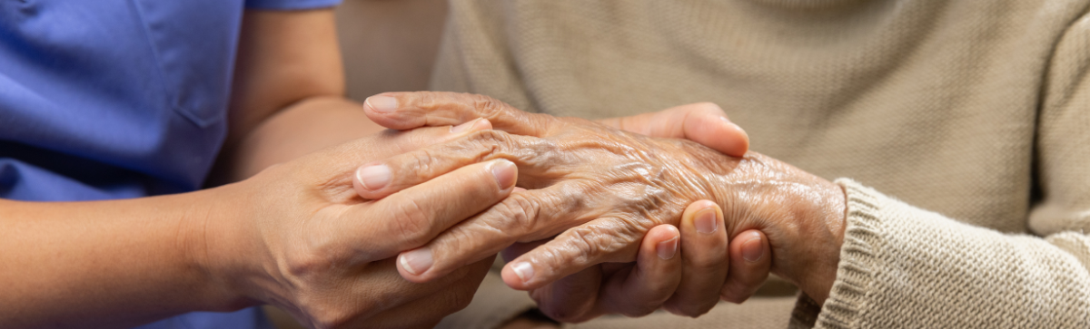 Nurse providing pain assessment to resident's hand.