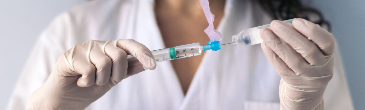 Nurse with syringe and vial of medication.